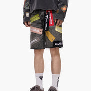 Person wearing gray shorts with colorful patches and a dark long-sleeve shirt on a white background