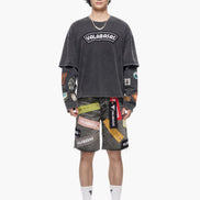 Person wearing a dark gray t-shirt with colorful patches and shorts on a white background