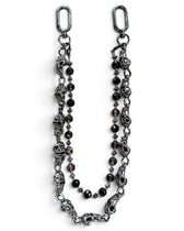 A gothic-style beaded chain accessory featuring antique silver-toned skull charms, faceted dark beads, and silver spacer beads, displayed on a clean white background.