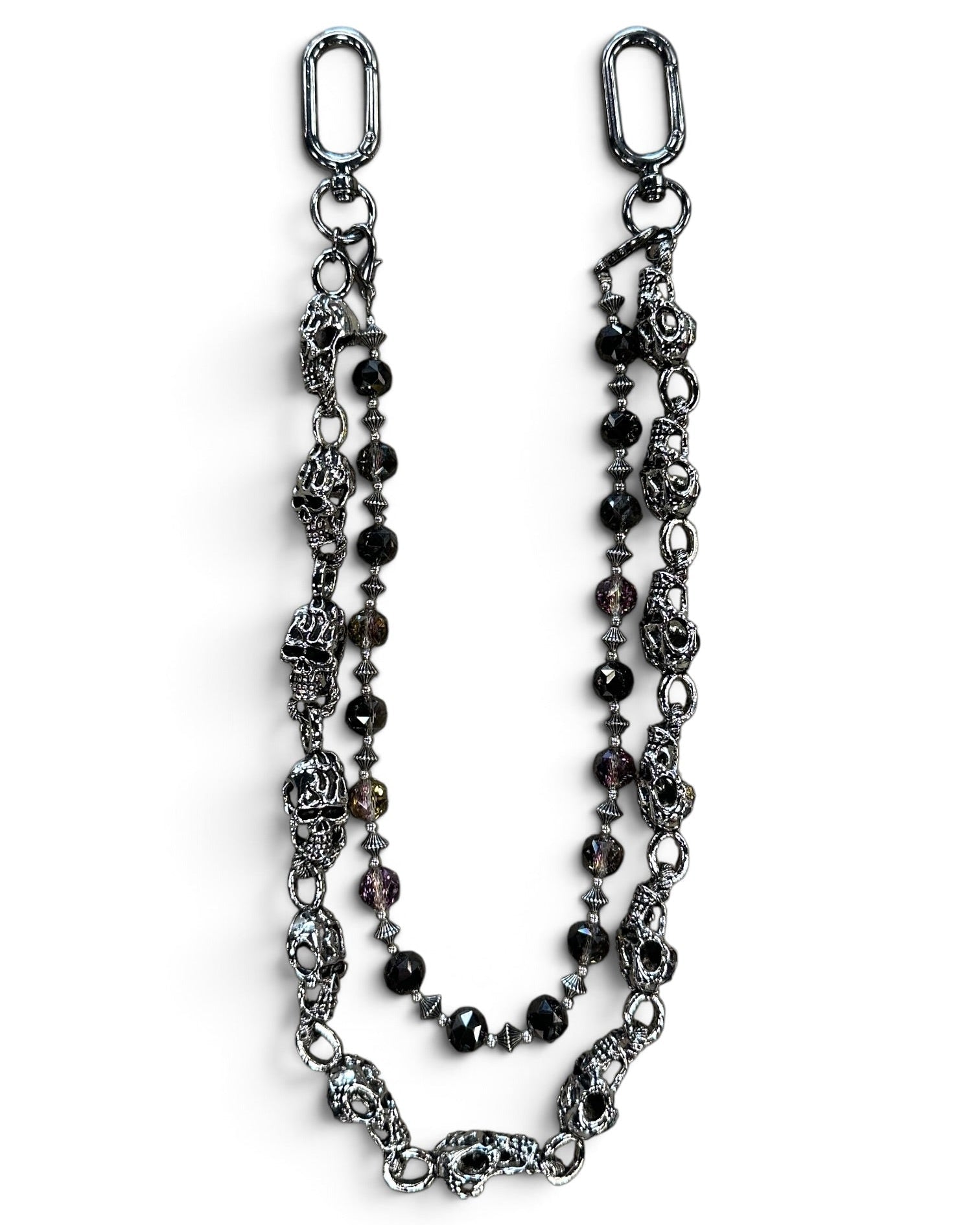 A gothic-style beaded chain accessory featuring antique silver-toned skull charms, faceted dark beads, and silver spacer beads, displayed on a clean white background.