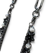 A close-up of a dark gunmetal chain accessory with star-shaped charms and clear rhinestone-covered beads, shown against a plain white background.