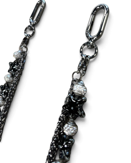 A close-up of a dark gunmetal chain accessory with star-shaped charms and clear rhinestone-covered beads, shown against a plain white background.
