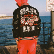 Person wearing a black jacket with red and white text by the ocean
