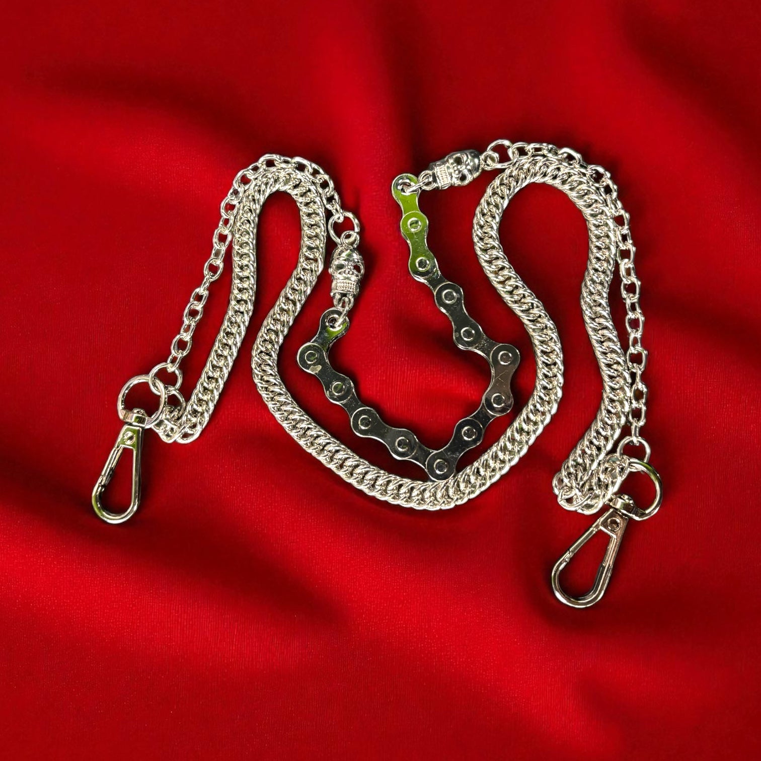Silver chain with metal clasp on a red fabric background