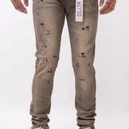 Person wearing distressed gray jeans with a visible brand label on a white background