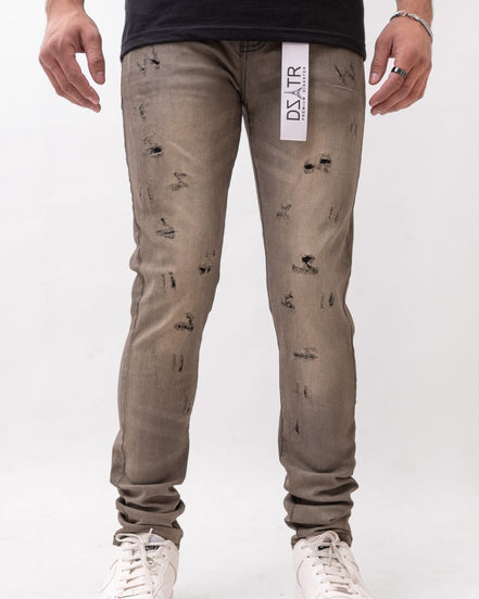 Person wearing distressed gray jeans with a visible brand label on a white background