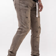 Person wearing distressed gray pants with a white background