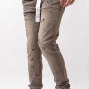 Person wearing distressed beige pants with a visible brand label on a white background
