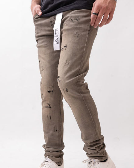 Person wearing distressed beige pants with a visible brand label on a white background
