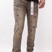 Person wearing distressed gray pants with a visible brand label on a white background