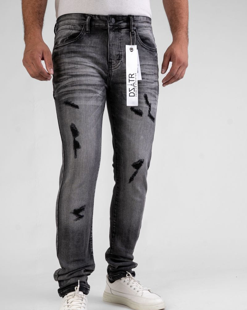 Person wearing gray distressed jeans with a visible brand tag on a white background