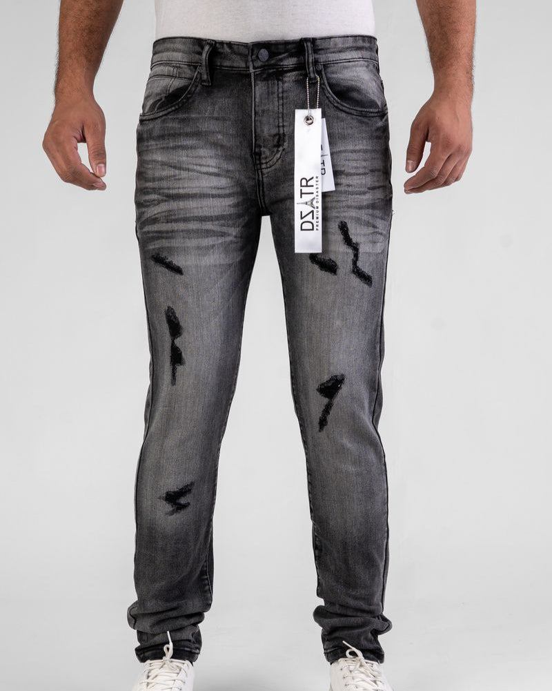 Gray distressed jeans with a brand tag on a white background