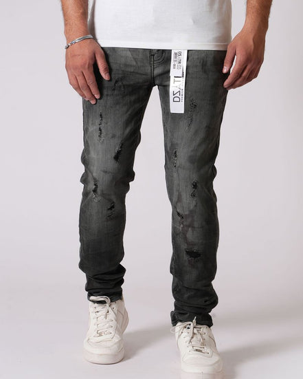 Person wearing black distressed jeans with a white label on a white background