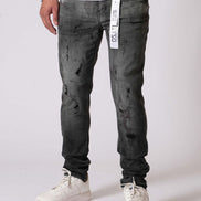 Person wearing black distressed jeans and white sneakers on a white background