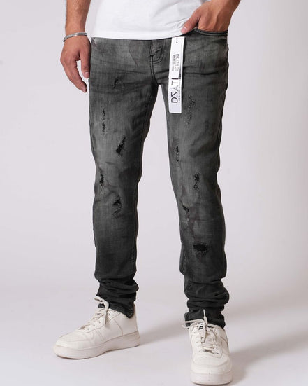 Person wearing black distressed jeans and white sneakers on a white background