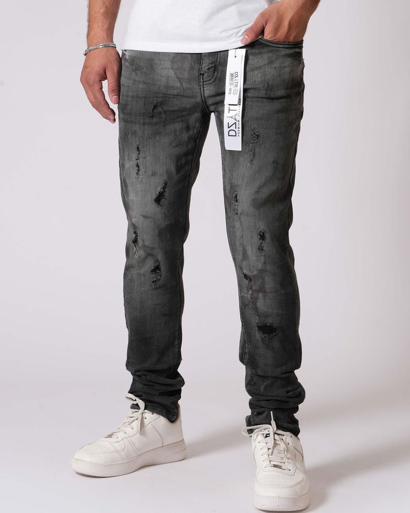 Person wearing black distressed jeans and white sneakers on a white background