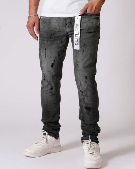 Person wearing black distressed jeans and white sneakers on a white background