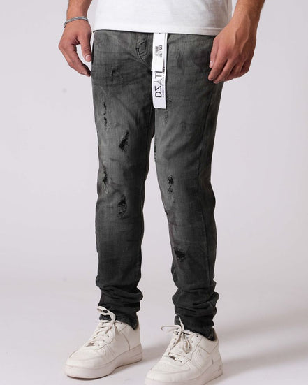 Person wearing dark distressed jeans with a white label on a light gray background