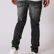 Person wearing black jeans and white sneakers on a plain background