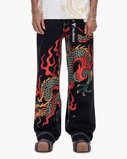 Black pants with colorful dragon design worn by a person on a white background