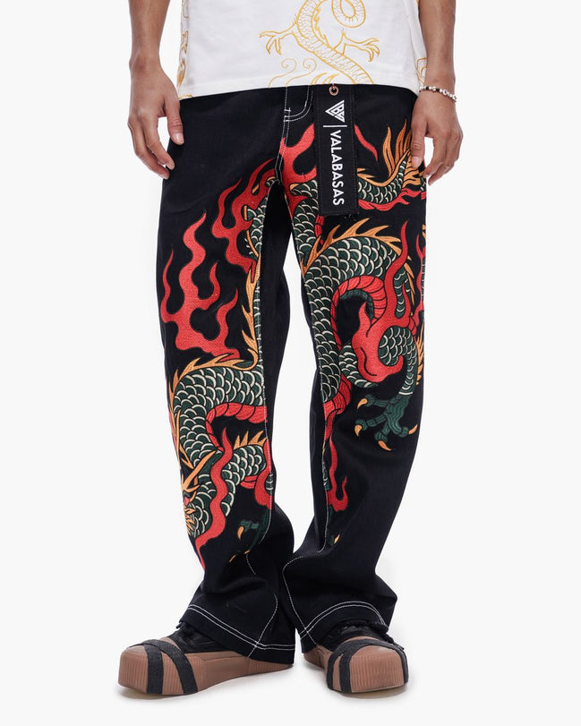 Black pants with colorful dragon design worn by a person on a white background