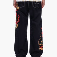 Black pants with colorful dragon designs on a white background