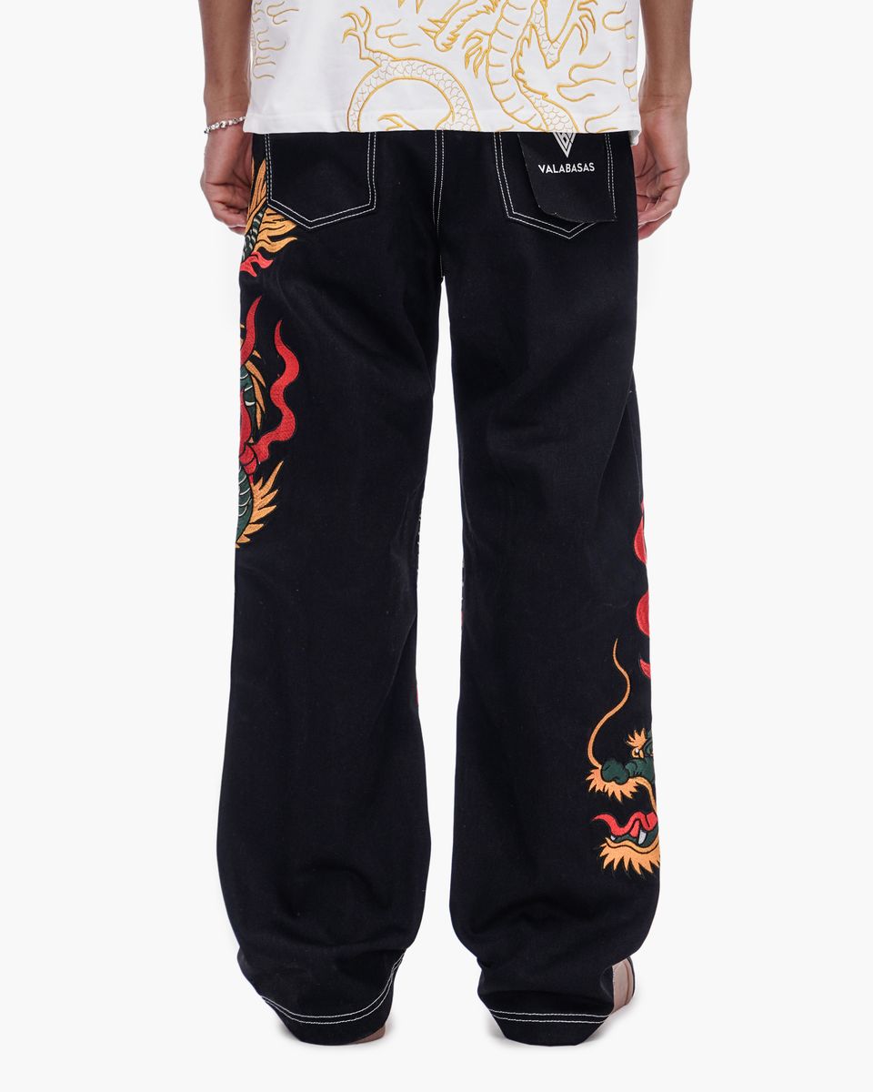 Black pants with colorful dragon designs on a white background