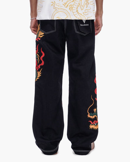 Black pants with colorful dragon designs on a white background