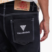 Black pants with a visible brand logo and text on the pocket, on a plain background.