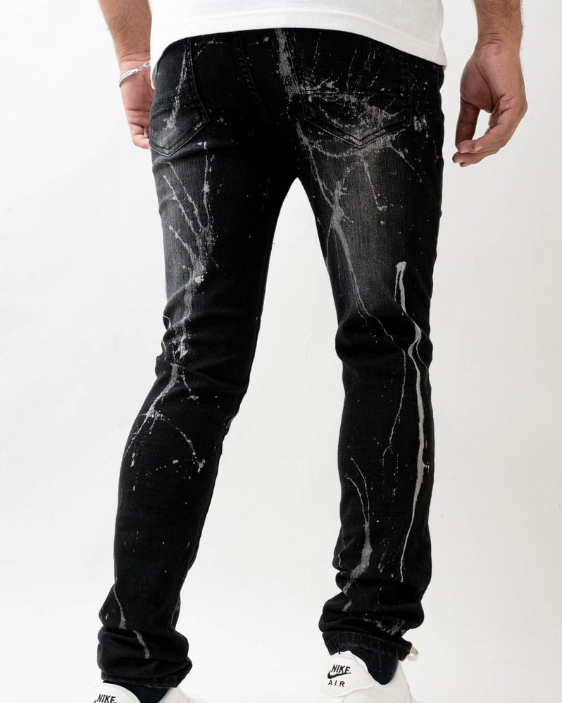 Black distressed jeans worn by a person on a white background
