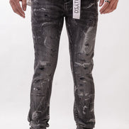 Person wearing black distressed jeans with a visible brand label on a white background
