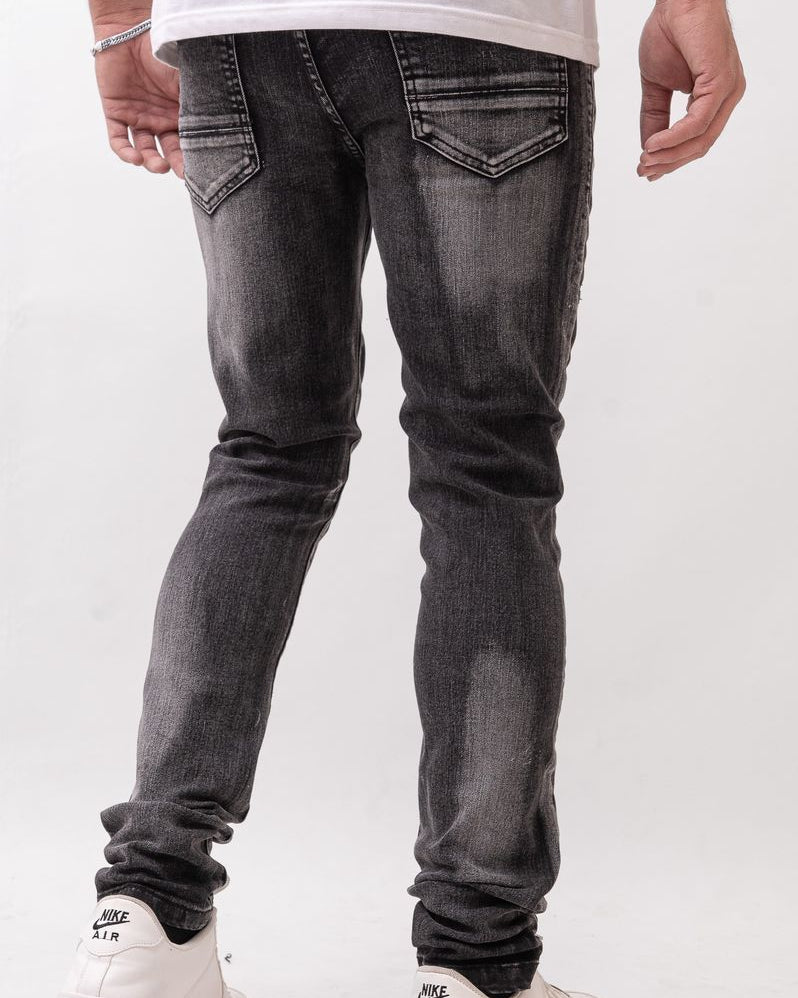 Person wearing black jeans and white sneakers on a white background