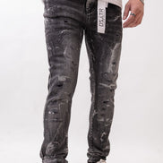Person wearing distressed black jeans with a visible brand label on a white background