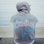 person wearing an all grey hoodie with large branding and rhinestone details. 