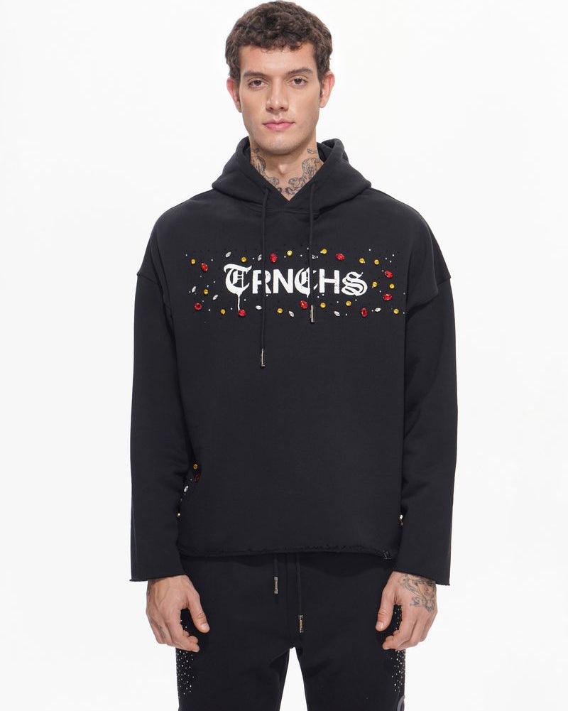 Person wearing a black hoodie with colorful text design on a white background