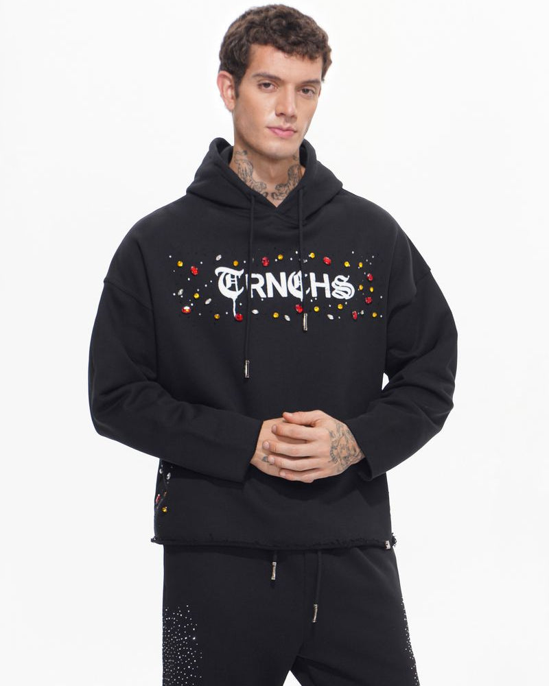 Man wearing a black hoodie with colorful text design on a white background