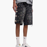 Person wearing black shorts with colorful patterns and white sneakers on a white background
