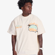 Man wearing a cream t-shirt with a colorful graphic design on a white background