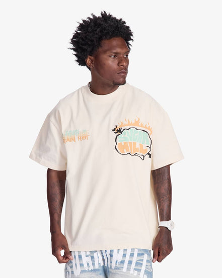 Man wearing a cream t-shirt with a colorful graphic design on a white background