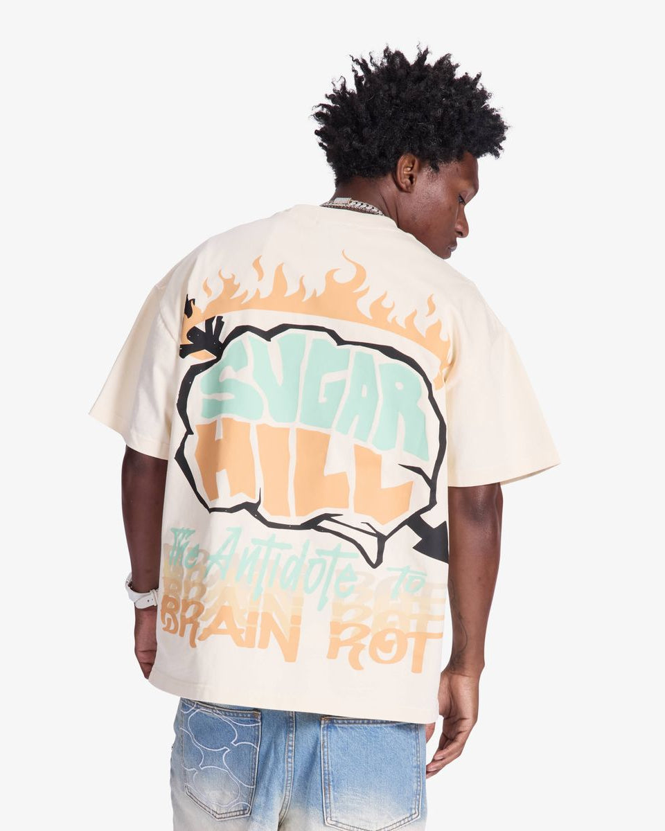 Person wearing a white t-shirt with colorful graphics and text on a plain background