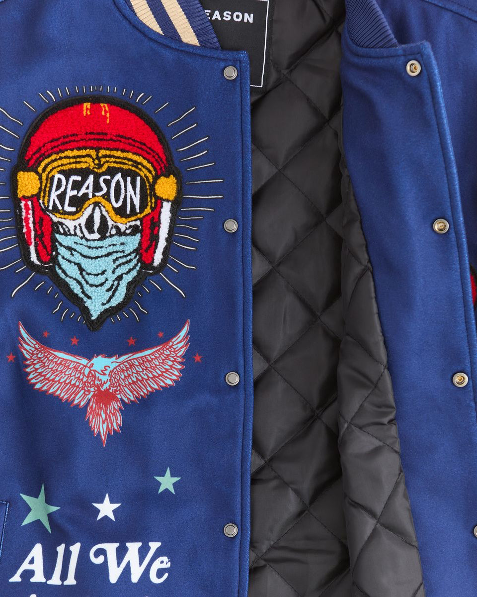 Blue jacket with embroidered design and 'Reason' text on a black background
