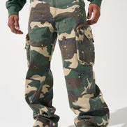 Person wearing camouflage pants and red sneakers on a white background