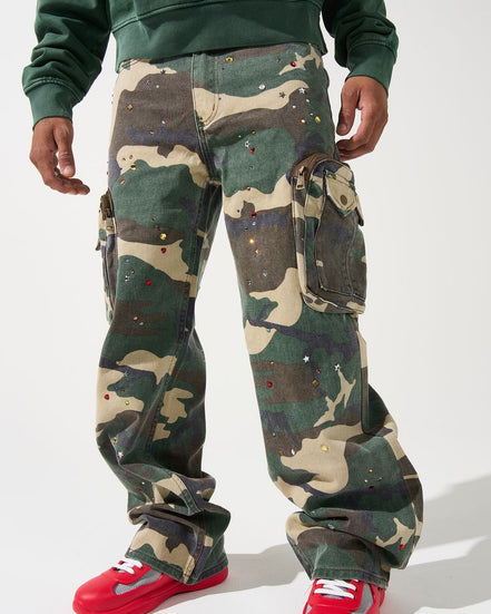 Person wearing camouflage pants and red sneakers on a white background