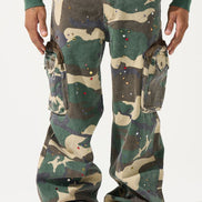 Camouflage pants worn by a person with red shoes on a white background