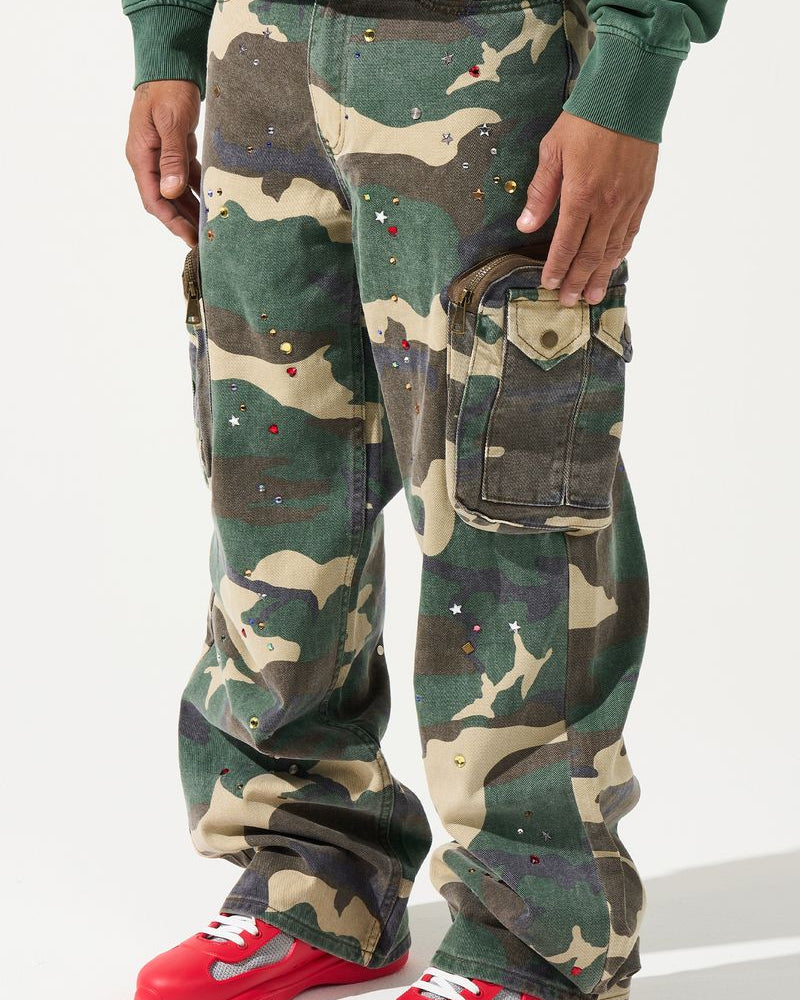 Person wearing camouflage pants with red shoes on a white background