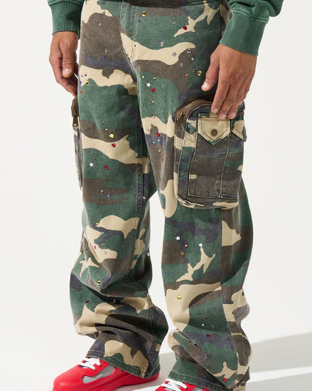 Person wearing camouflage pants with red shoes on a white background