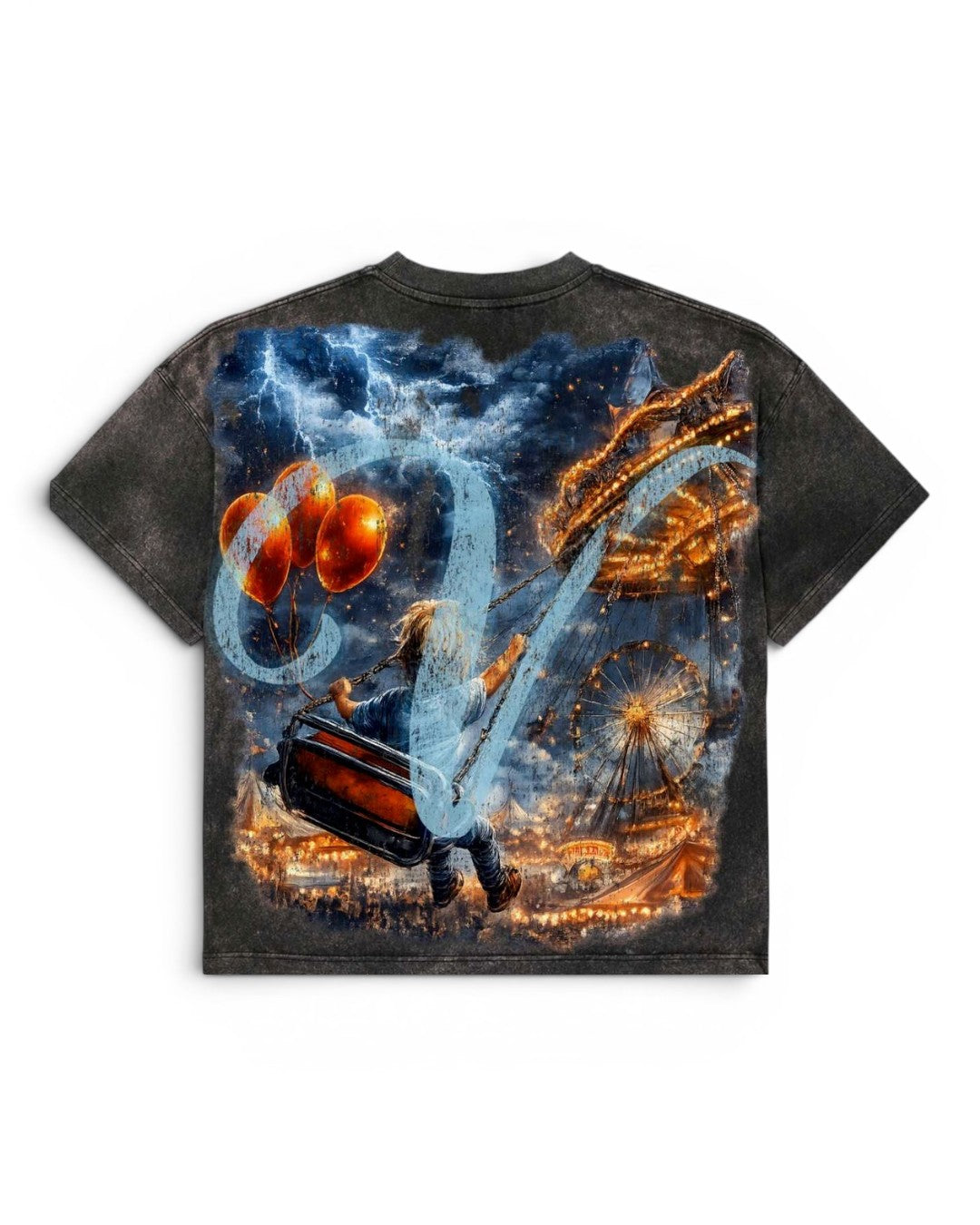 A short-sleeve t-shirt with a dark gray mineral-wash finish, featuring a large, vibrant graphic print on the back. The print depicts a whimsical fantasy scene with a person carrying a suitcase, glowing orange balloons, a Ferris wheel, and a swirling blue and white abstract shape against a dark, stormy sky.