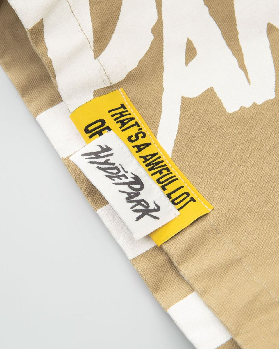 Close-up of a beige fabric with a white graphic and a yellow tag with text.