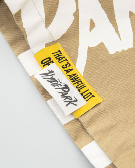 Close-up of a beige fabric with a white graphic and a yellow tag with text.