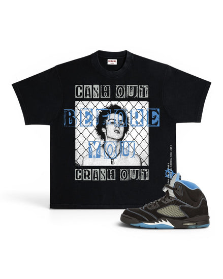 A black graphic t-shirt featuring a portrait of Mary Jane and the text 'CASH OUT BEFORE YOU CRASH OUT' in white and blue, shown next to a black and blue high-top sneaker on a white background.